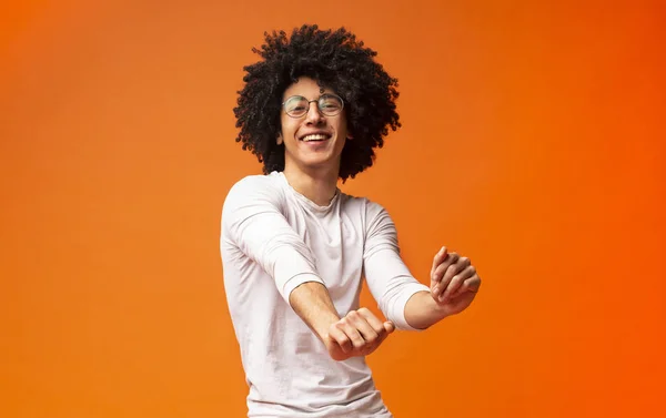 Homem americano africano feliz se movendo em fundo laranja — Fotografia de Stock