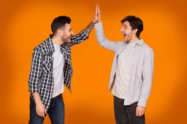 Happy Friends Giving High Five, Orange Background