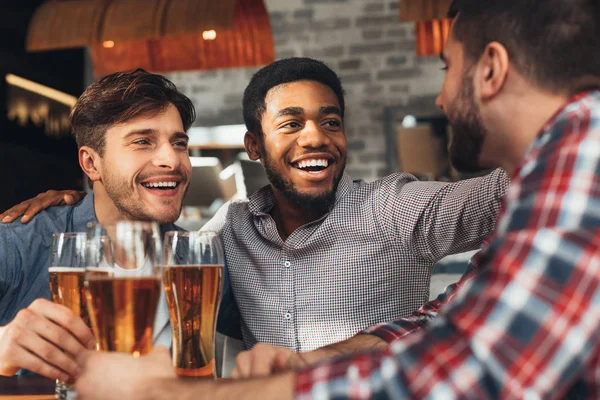 A partilhar notícias. Diversos amigos bebendo cerveja no bar — Fotografia de Stock