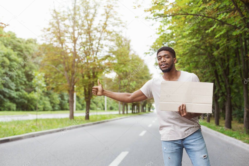 Man hitchhiking on road