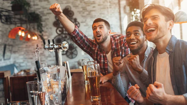 Amigos viendo el partido de fútbol en el bar y beber cerveza — Foto de Stock