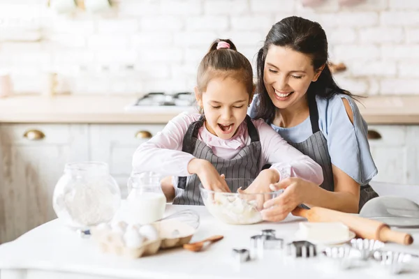 Mother and her daughter preparing dough to make cake — Stock Photo, Image