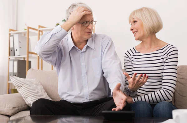 Ältere Paare berechnen Rechnungen, diskutieren über Hauswirtschaft — Stockfoto