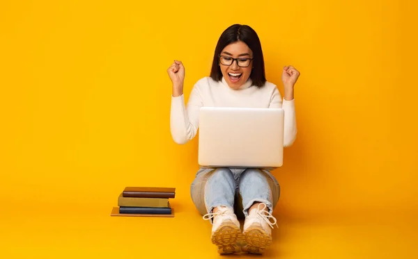 Освітня концепція. Happy студент дівчина з книгами і ноутбуком, жовтий фон — стокове фото
