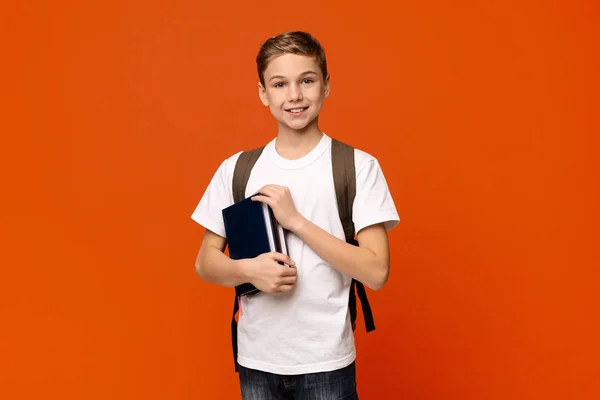 Vrolijke jongen met rugzak houden boeken — Stockfoto