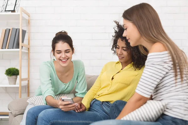 Girl showing funny video on smartphone to friends — Stock Photo, Image