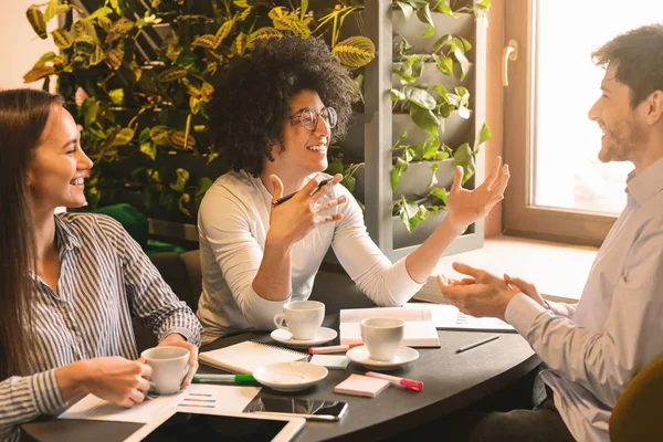 Inspired black guy explaining his great ideas to colleagues — Stock Photo, Image