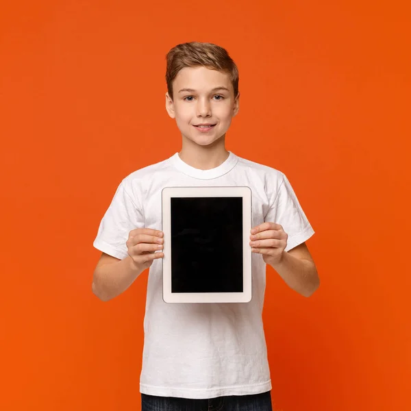 Kleine jongen toont digitale tablet met blanco scherm — Stockfoto
