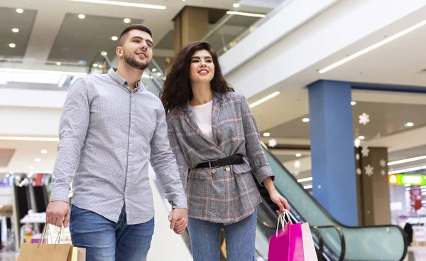 Couple heureux avec sacs à provisions marchant dans le centre commercial — Photo