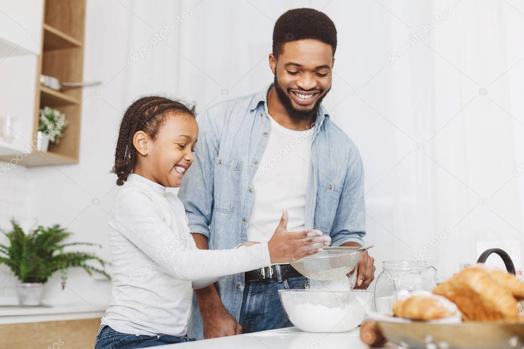 Father and child daughter cooking together