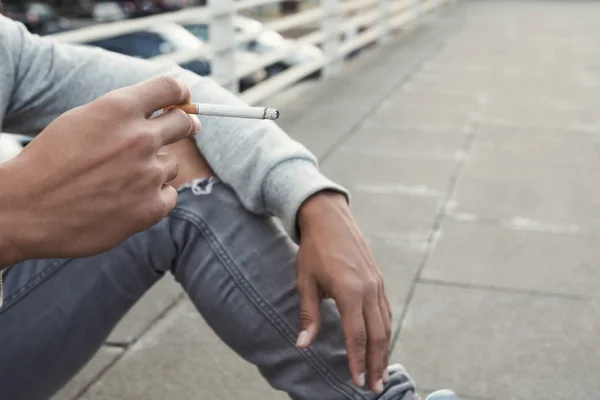 Teen Issues. Black teenager smoking cigarette, sitting alone — Stock Photo, Image