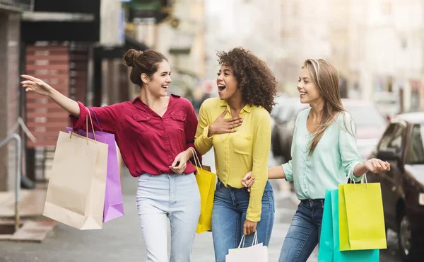 Jovens mulheres caminhando com sacos de compras na rua — Fotografia de Stock