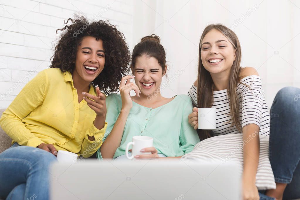 Friends watching funny movie and drinking coffee