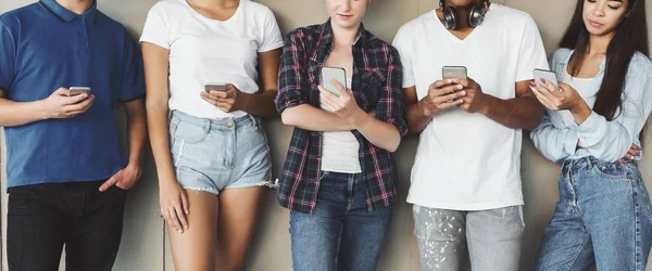 Adolescentes mensagens de texto de telefone celular, apoiando-se na parede urbana — Fotografia de Stock