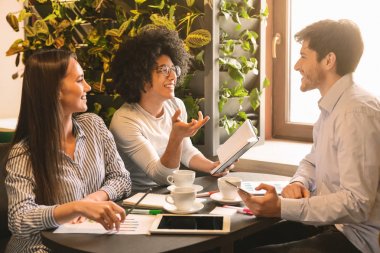 Kafede fikir alışverişinde bulunan çok ırklı genç iş adamları