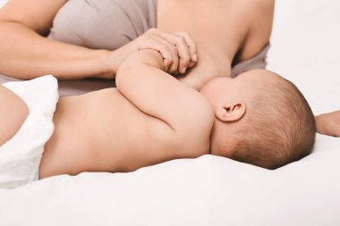 Anne bebeğini emziriyor ve sarılıyor.