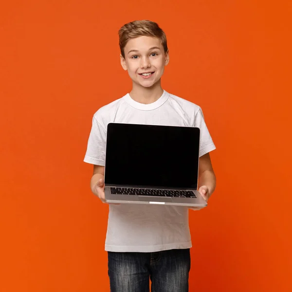 Feliz niño sonriente mostrando ordenador portátil en blanco — Foto de Stock