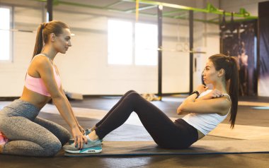 Kız kadın arkadaş yardımı ile sit-up egzersiz