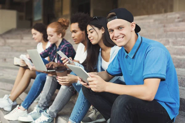 Adolescente cara usando tablet digital e sorrindo para a câmera — Fotografia de Stock