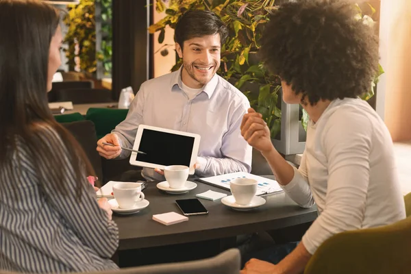 Três pessoas em restaurante discutindo projeto com tablet digital — Fotografia de Stock