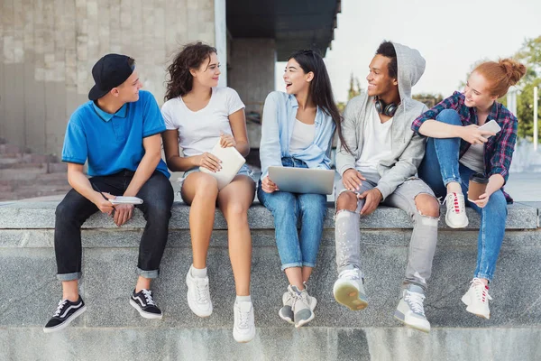 Adolescentes amigos usando gadgets e conversando uns com os outros na vida real — Fotografia de Stock