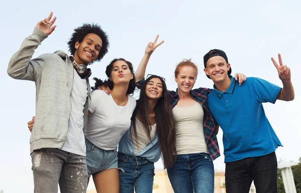 Groupe d'adolescents heureux embrassant et souriant à la caméra — Photo