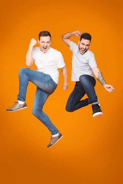 Dua Friends Jumping And Celebrating Success Over Yellow Background — Stok Foto