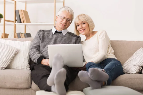 Abuelos modernos. Pareja mayor Websurf en el ordenador portátil — Foto de Stock