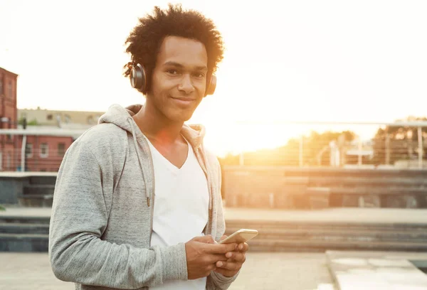 Хлопчик-підліток слухає музику та використовує телефон у міських налаштуваннях — стокове фото