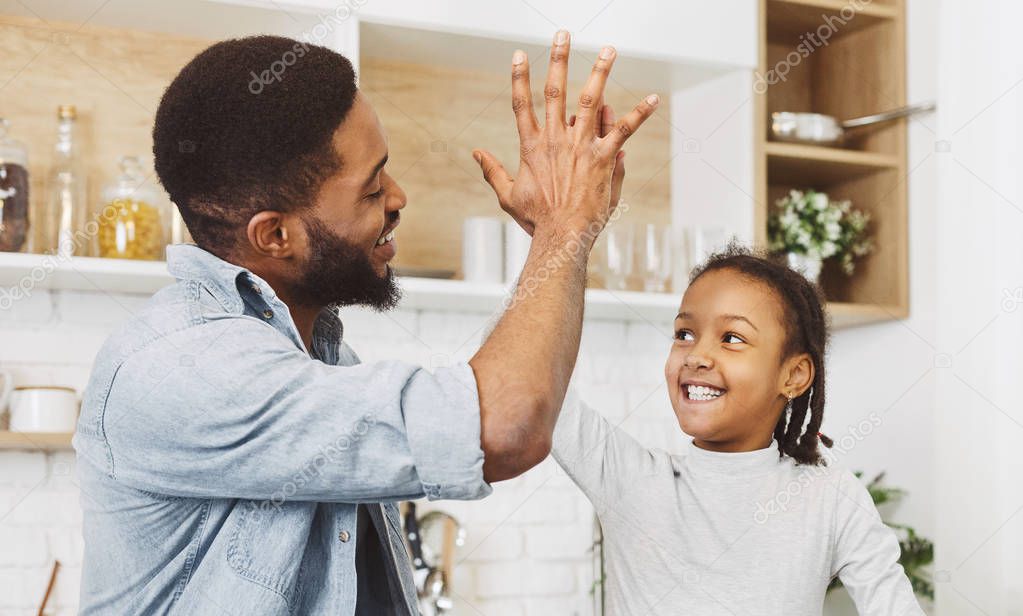 Afro child girl giving five with her dad
