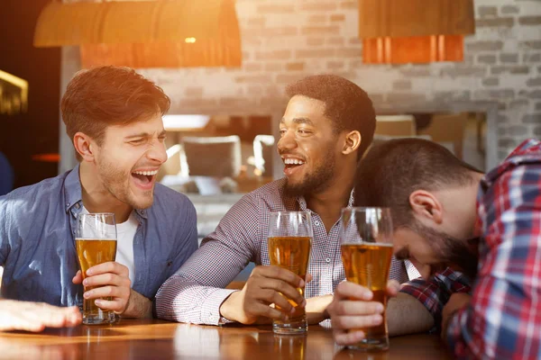 Divers amis boire de la bière et parler dans le bar — Photo