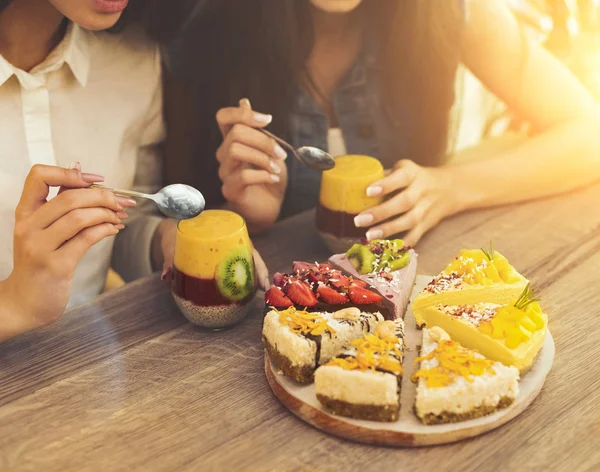 Két lány étkezési egészséges sütemények és smoothie — Stock Fotó