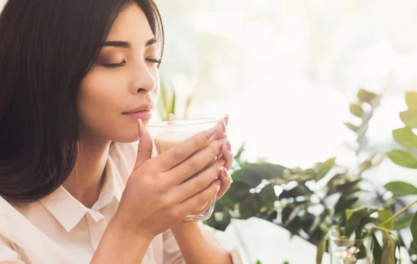 Приваблива азіатська жінка насолоджується запахом ранкової кави — стокове фото