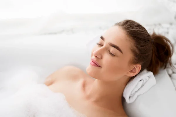 Joven mujer disfrutando agradable baño con espuma —  Fotos de Stock