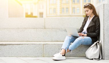 Genç bir kadın bilgisayarla video mesajı gönderiyor.