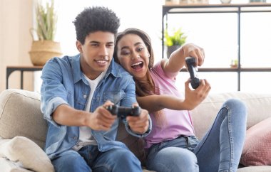 Mutlu gençler evde joystick ile video oyunu oynuyor