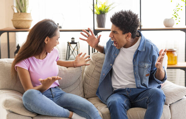 Teenagers boy and girl quarreling, gesticulating and shouting at each other