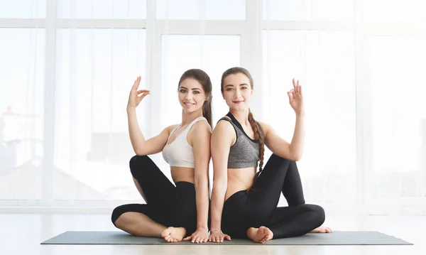Atrakcyjne młode kobiety robią jogę siedząc z powrotem do tyłu — Zdjęcie stockowe