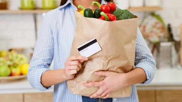 Жінка з кредитною та паперовою сумкою з продуктами — стокове фото