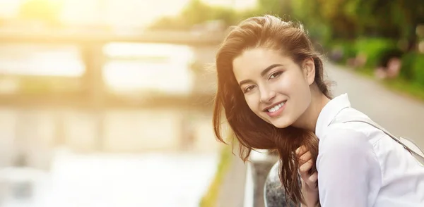 Gorgeous woman admires the sunset in the park and smiling — Stock Photo, Image