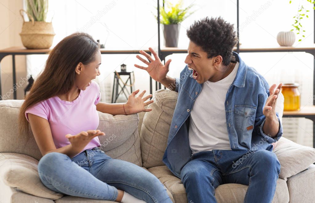 Teenagers boy and girl quarreling, gesticulating and shouting at each other
