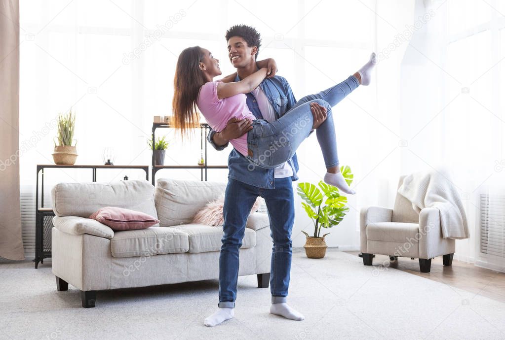 Romantic teen african american couple dancing at home