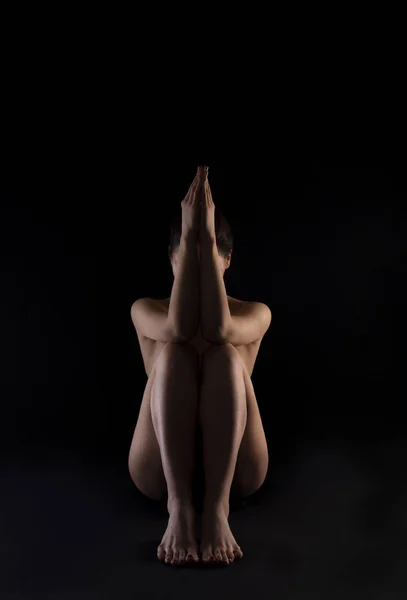 Körpersilhouette einer nackten Frau, sitzend auf schwarzem Hintergrund. — Stockfoto