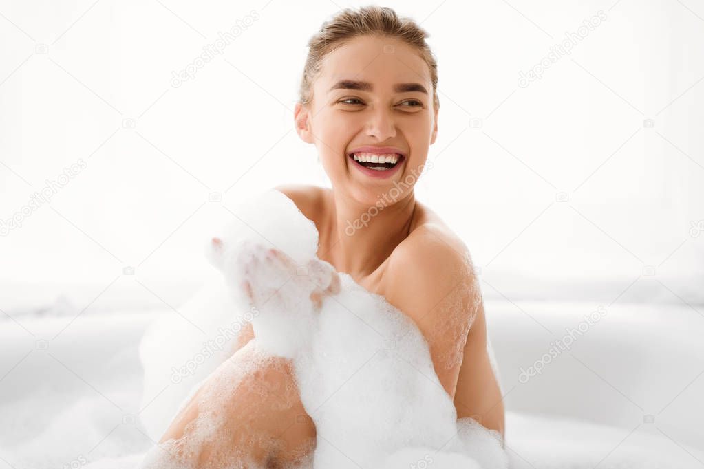 Happy Woman Playing With Foam In Bathtub