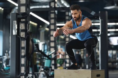 Crossfit sporcu spor salonunda atlama egzersizi yapıyor.
