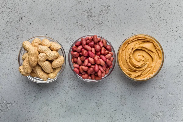 Cuencos con cacahuetes y mantequilla de cacahuete — Foto de Stock