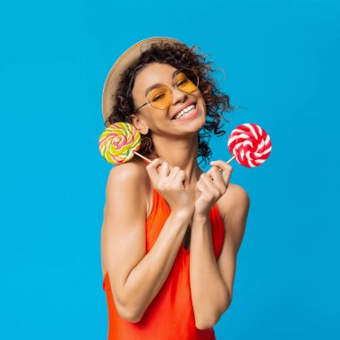 Mutlu afrikalı kız şeker zevk, iki büyük lolipop ile gülümseyen