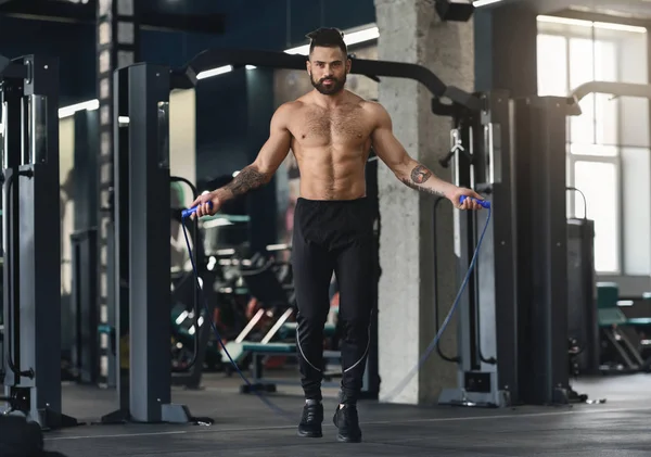 Musculoso hombre de entrenamiento con saltar la cuerda en el gimnasio —  Fotos de Stock