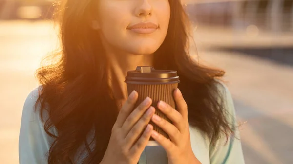 Chica oliendo chocolate caliente en la taza para llevar, al aire libre — Foto de Stock