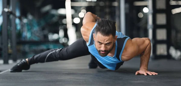 Muscular man doing push ups on on hands in gym — Stock Photo, Image